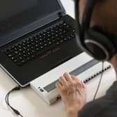 Global Accessibility Awareness Day focuses on digital access and inclusion for people with disabilities or impairments. (Image shows visually impaired person working on computer with assistive technology) 