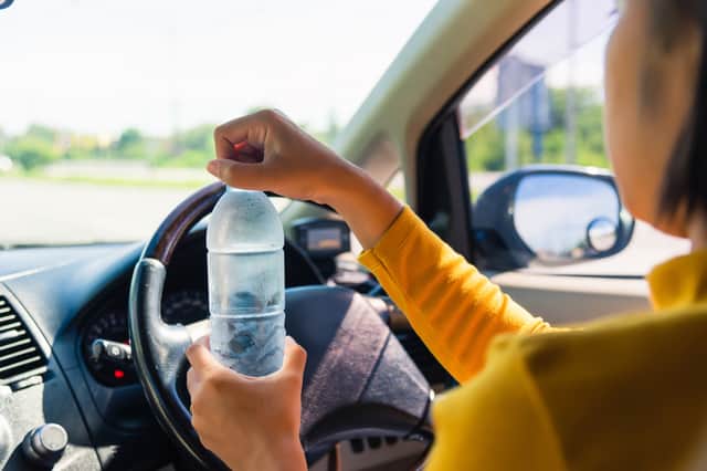 It’s not illegal to drink water while driving but you do need to remain in control and focused on driving 