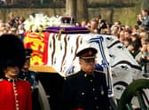 Soldiers accompany a gun carriage holding the coffin bearing the Queen Mother April 5, 2002.