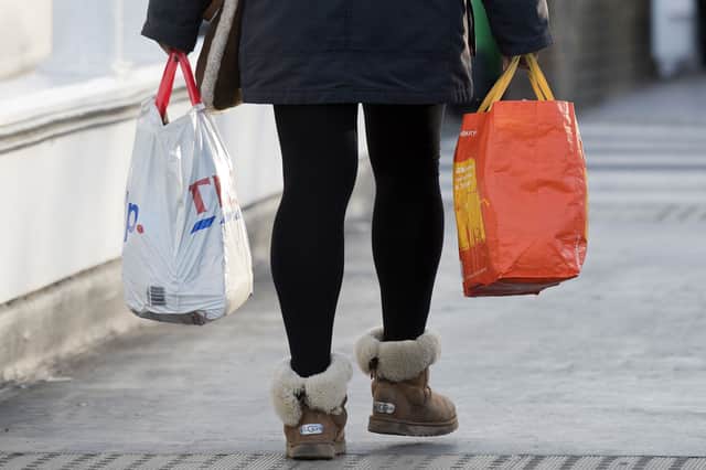 A person leaves with their goods in reusable plastic carrier bags after shopping.
