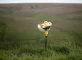 Floral tributes overlook Saddleworth Moor where the body of missing Keith Bennett may be buried.