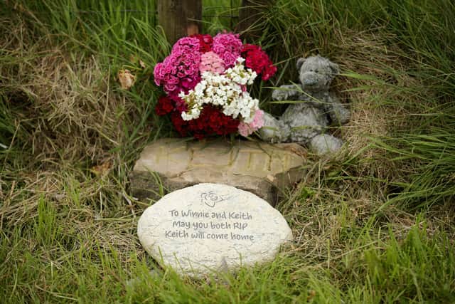 A plaque in memory of Keith Bennett and his mother Winnie Johnson sits next to floral tributes overlooking Saddleworth Moor where the body of missing Keith Bennett may be buried.