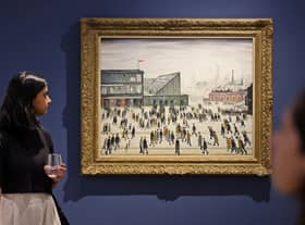 A visitor walks past "Going to the Match" by English artist LS Lowry from 1928, on display at a Christie's exhibition in Dubai on September 15, 2022