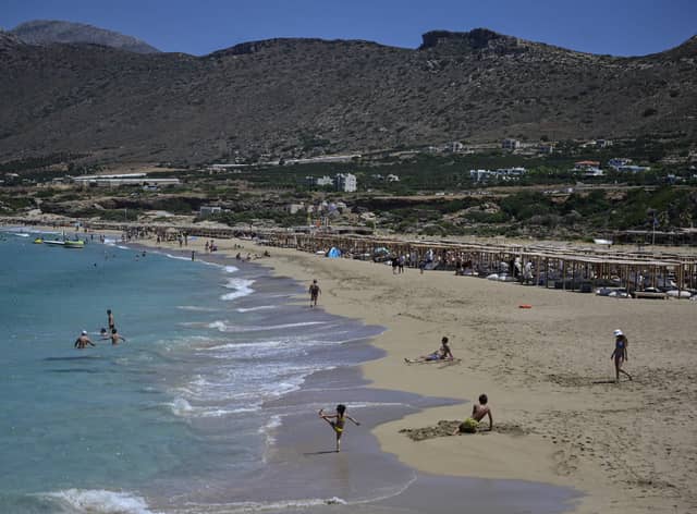 Tourists enjoy the beach in Phalasarna, northwest of the Greek mediterranean island of Crete