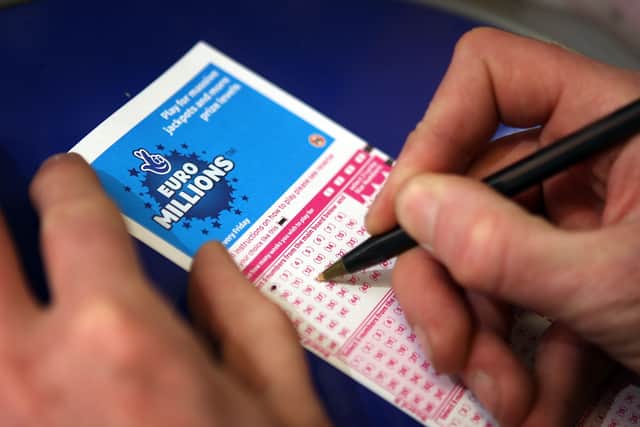 A punter fills out a National Lottery ticket.