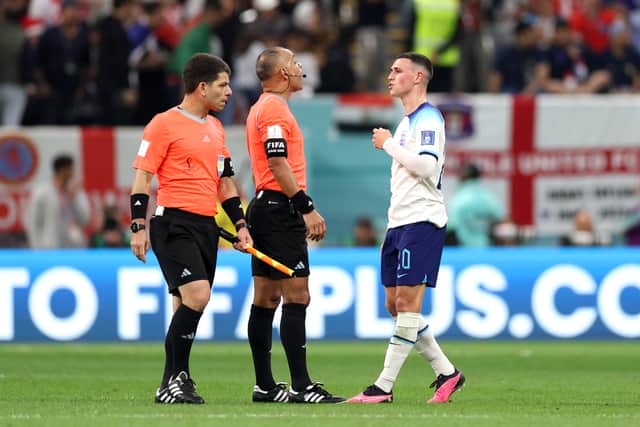 Phil Foden of England speaks with referee Wilton Sampaio and assistant referee Bruno Boschilia during the FIFA World Cup quarter-final defeat against France (Photo by Richard Heathcote/Getty Images)