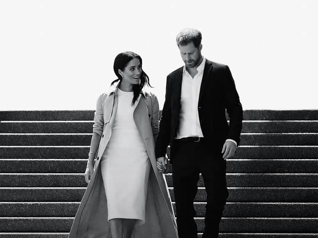 A black and white image of Meghan Markle and Prince Harry walking down a flight of stairs together, hand in hand and smiling (Credit: Netflix) 