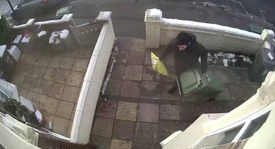 A CCTV camera captured the moment a Christmas parcel was stolen only minutes after an Evri delivery driver bizarrely hid the package under a wheely bin outside the front door. 