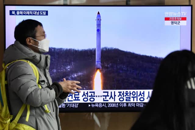A man walks past a television screen showing a news broadcast with file footage of a North Korean missile test, at a railway station in Seoul on December 31, 2022 after North Korea fired three short-range ballistic missiles according to South Korea's military. 