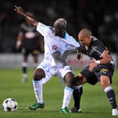 (FILES) In this file photo taken on September 13, 2008 Girondin’s forward Yoan Gouffran (R) fights for the ball with with Marseille’s Cameroonian midfielder Modeste M’ Bami during the French L1 football match between Bordeaux and Olympique de Marseille, at the Chaban Delmas stadium in Bordeaux, southwestern France. - Cameroonian Modeste M’Bami, former midfielder for Paris Saint-Germain and Olympique de Marseille died aged 40 in Le Havre, announces sports agent Frank Belhassen, on January 7, 2023. (Photo by PIERRE ANDRIEU / AFP) (Photo by PIERRE ANDRIEU/AFP via Getty Images)