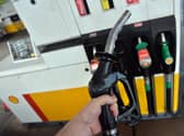 A man poses holding a petrol pump nozzle at a filling station in Birkenhead, north-west England.  (Photo credit should read PAUL ELLIS/AFP via Getty Images)