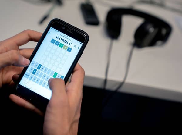 This photo illustration shows a person playing online word game “Wordle” on a mobile phone in Washington, DC on January 11, 2022 (Photo by STEFANI REYNOLDS/AFP via Getty Images)