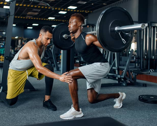 Man with his trainer in gym (Adobe)