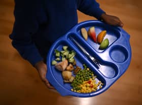 A child carries a tray with food during lunch-break at St Mary’s RC Primary School, in Battersea, south London.