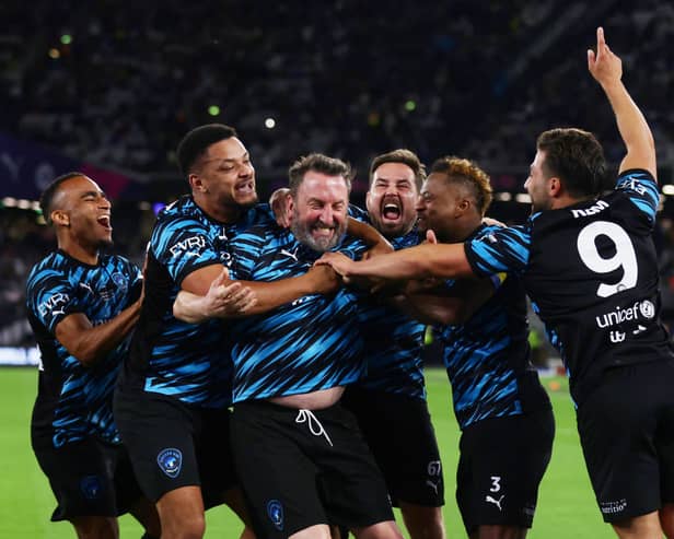 Lee Mack celebrates his goal with World XI teammates including Steven Bartlett (left-centre)