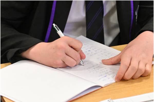 Year 11 students, wearing face coverings, take part in a GCSE maths class at Park Lane Academy in Halifax, northwest England on March 8, 2021 as schools reopen following the easing of lockdown restrictions. (Photo by Oli SCARFF / AFP) (Photo by OLI SCARFF/AFP via Getty Images)