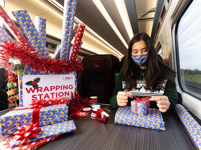 Professional gift wrapper Finn Drumgoole wraps presents for LNER customers to launch the rail operators complimentary Rail Wrapping service (photo: David Parry/PA Wire)