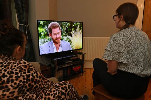 A family gather around the television in Liverpool to watch Prince Harry and his wife Meghan's explosive tell-all interview with Oprah Winfrey in March (Photo: PAUL ELLIS/AFP via Getty Images)