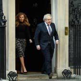 Prime Minister Boris Johnson and his partner Carrie Symonds stand outside the door of number 10 Downing Street (Photo by Leon Neal/Getty Images)