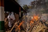 A priest avoids funeral pyres in India, which has been badly hit by a surge in coronavirus cases. (Photo by Anindito Mukherjee/Getty Images)