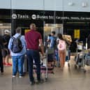 People queue for a lift at Heathrow Airport.