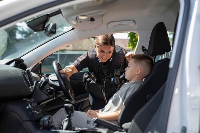 Sgt Amelia Moore shows Ronnie inside of police car.