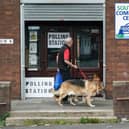 Man takes a dog to a polling station