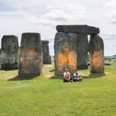 Activists sitting by Stonehenge after it was sprayed orange (Photo: Just Stop Oil / Supplied)