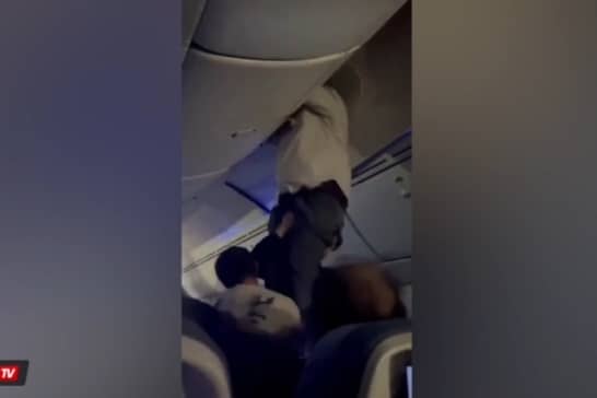 Passengers help man from overhead bin after 'strong turbulence'.
