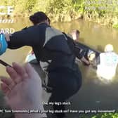 Woman is rescued from neck-level flood water in submerged car.