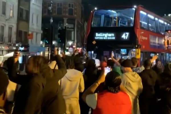 Excited England fans dance around “Bellingham” bus.