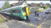 Shocking CCTV films the moment a girl risks her life at a level crossing, walking just a couples of metres in front of an advancing train.