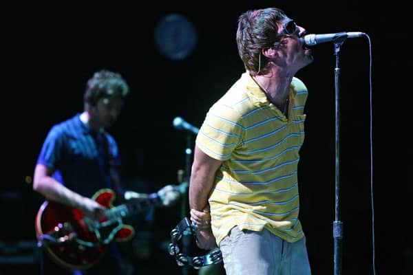Liam (R) and Noel Gallagher perform on stage. Photo: JOSE JORDAN/AFP via Getty Images