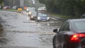 Drivers make their way through flooded roads.