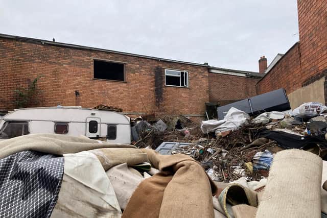 A caravan is nestled in the rubbish at the rear of the factory