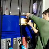 Dr Patrick Hart cracks the display panels of petrol pumps at Esso Thurrock Services on the M25 on August 24 2022. 