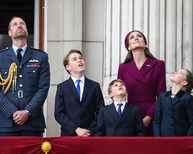 Prince William, Prince of Wales, Prince George of Wales, Prince Louis of Wales, Catherine, Princess of Wales and Princess Charlotte of Wales watch the Red Arrows flypast from Buckingham Palace.