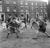 Children using dustbin lids and broomsticks as shields and lances during a game of knights in Liverpool in May 1956