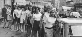 Fifteen young women in mini skirts wait to board a BMC Mini in July 1966 to break the world record for passengers in a Mini