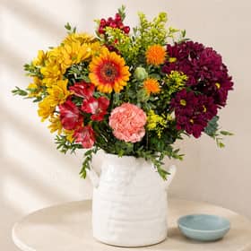 Bunches’ Autumn Sunrise bouquet combines warm yellow, orange, red and burgundy blooms for a colourful seasonal display.