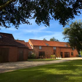 South Barn sits in the Lincolnshire countryside, with a gravelled driveway providing off-road parking for several vehicles