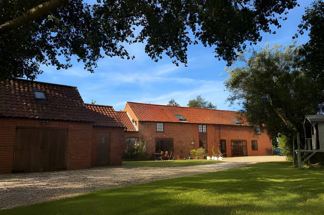 South Barn sits in the Lincolnshire countryside, with a gravelled driveway providing off-road parking for several vehicles