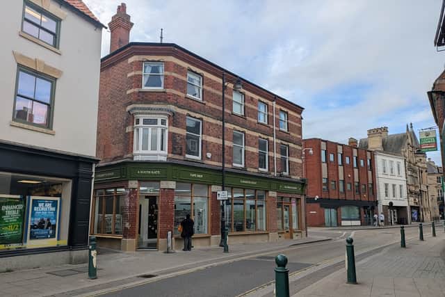 New shopfront with traditional signage, historic stonework detailing reinstated, and original glazed brick revealed at 4 Southgate, Sleaford, as part of the UKSPF Shopfront Scheme.