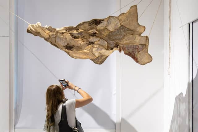 Visitor photographing work by Madara Vimba made from locally sourced hessian farming sacks.