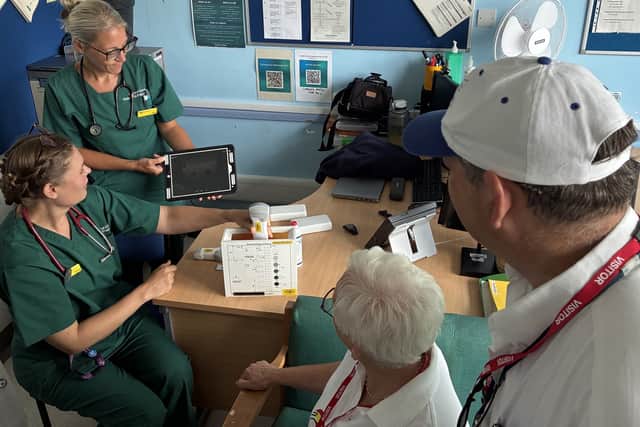 Advanced Critical Care Outreach Practitioner Emma Bradley showing hand-held ultrasound scanner to Sue Gosling and Bob Green of Local Hope.