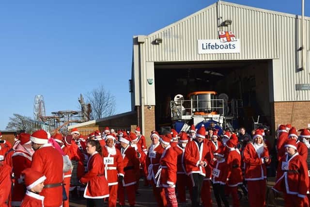 Santas gather outside the RNLI Lifeboat Station at the start of the run. Photo: Barry Robinson.