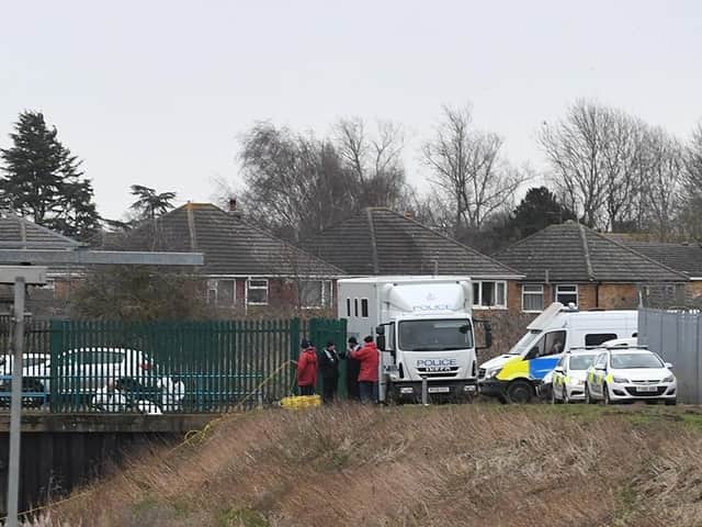 Detectives and forensic officers at the scene of the body find