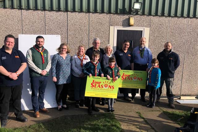 Outside the new door, from left - (back) Nick Hawridge - customer service manager of Four Seasons Windows, Daniel McCormack - Cubs Section Leader, Sally Howley - Headteacher of Browns Primary School, Helen Robinson - Group Scout Leader, Gordon and Margaret Lack of Bourne Lions, Matthew Rossetti - owner of Four Seasons, Trevor Watson - District Commissioner of Stamford and Bourne Scout Council, Chris Adkins - window fitter, (front) Scout Thomas Wilson, Cub Amelia McCormack - Cub and Beaver Lily McCormack. EMN-200202-163615001
