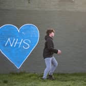 Children play football in the park next to graffiti in support of the NHS. Photo:Justin Setterfield