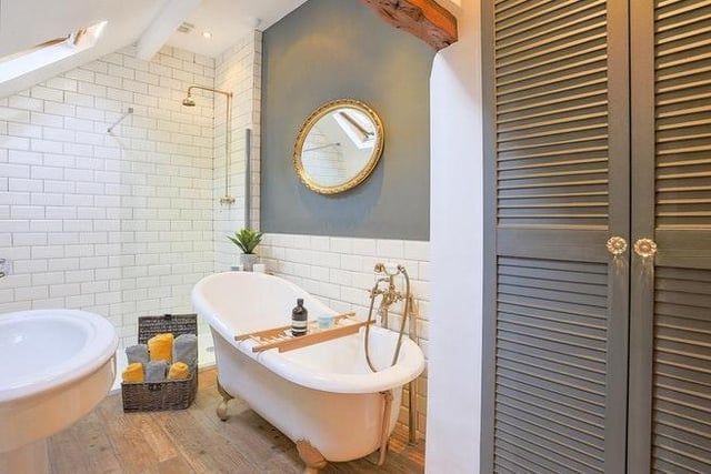 The luxury bathroom includes a roll top bath, traditional style wash basin, high level wc